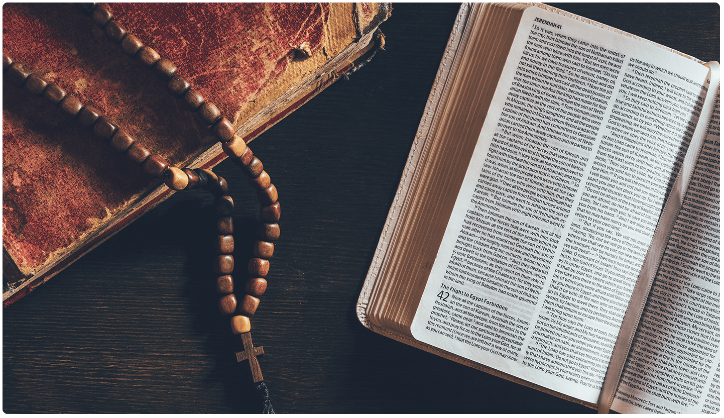 A bible and rosary on the table