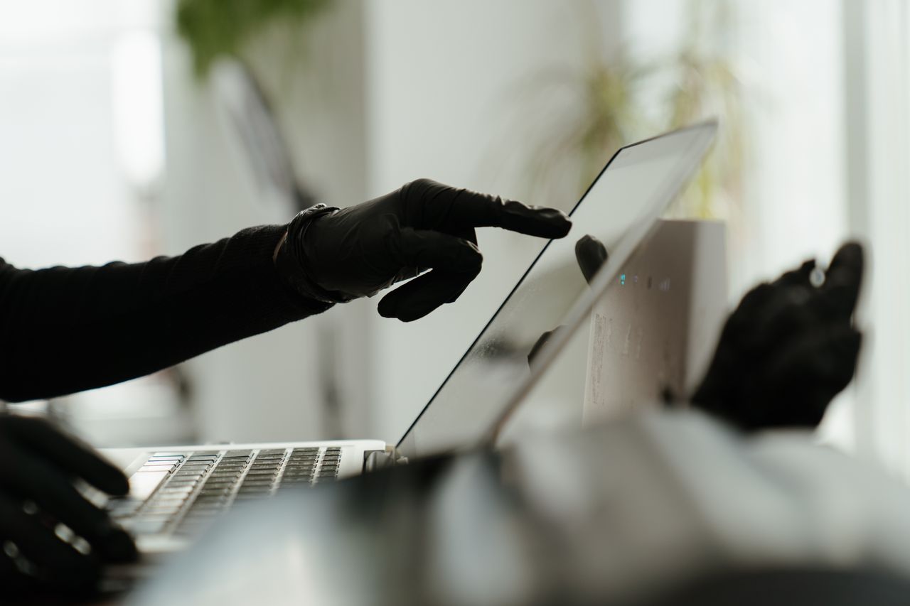 Gloved hands using a laptop touchscreen